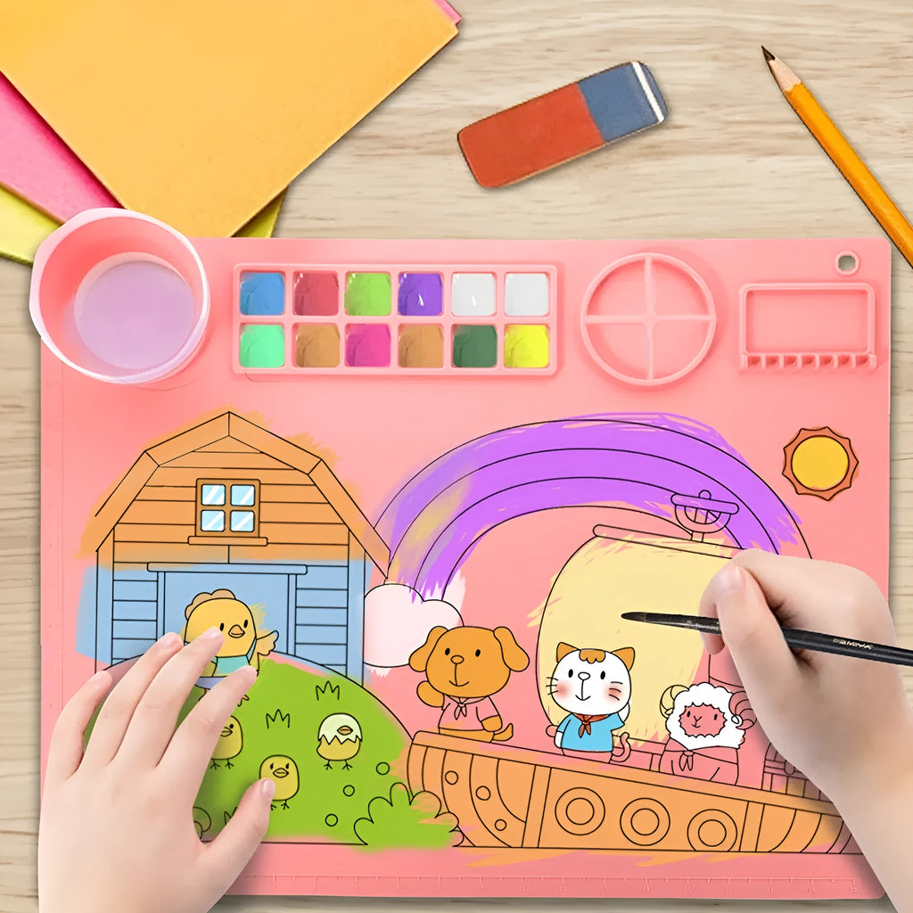 Light blue silicone painting mat with two round bowls, placed on a wooden table with paint brushes