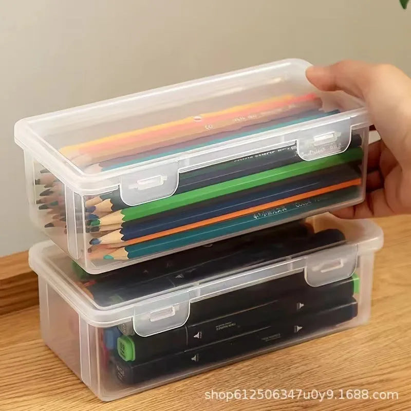 Clear transparent plastic storage box filled with coloured pencils and crayons with lid open.