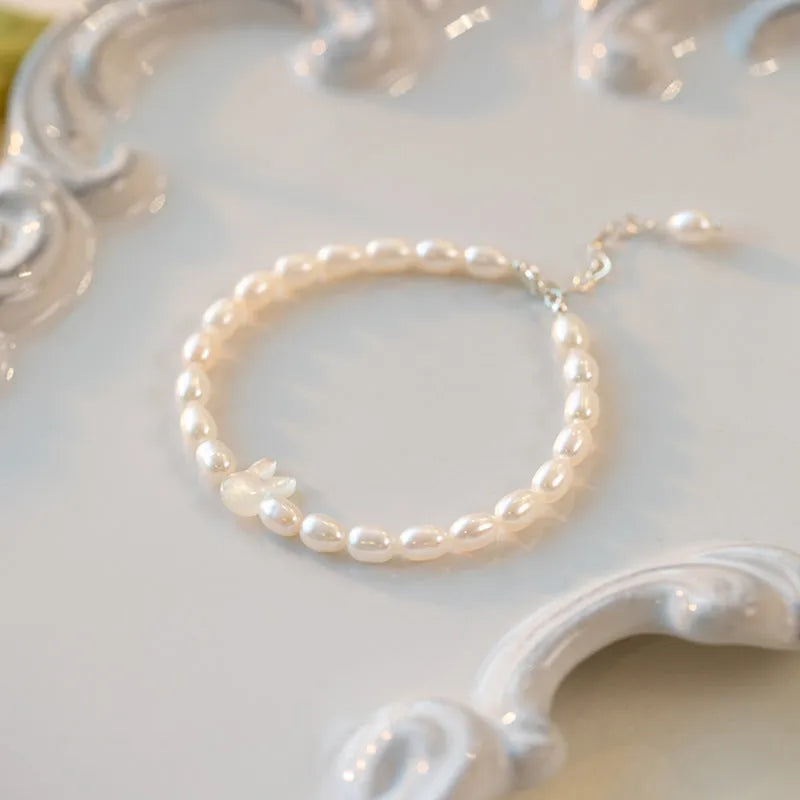 White pearl and 925 silver rabbit charm bracelet on a 16cm elastic string.