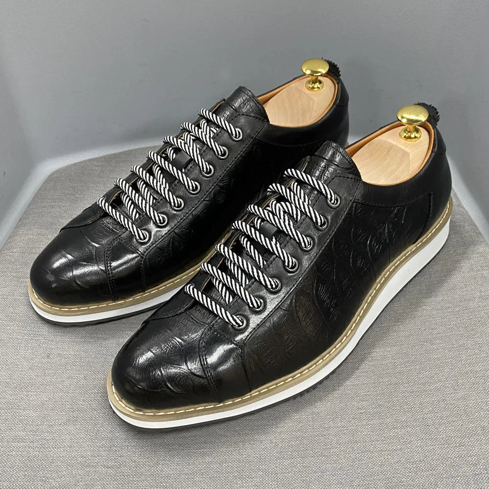 Men's low-top handmade shoes with embossed pattern on front, showing front-tie laces and grey colour.