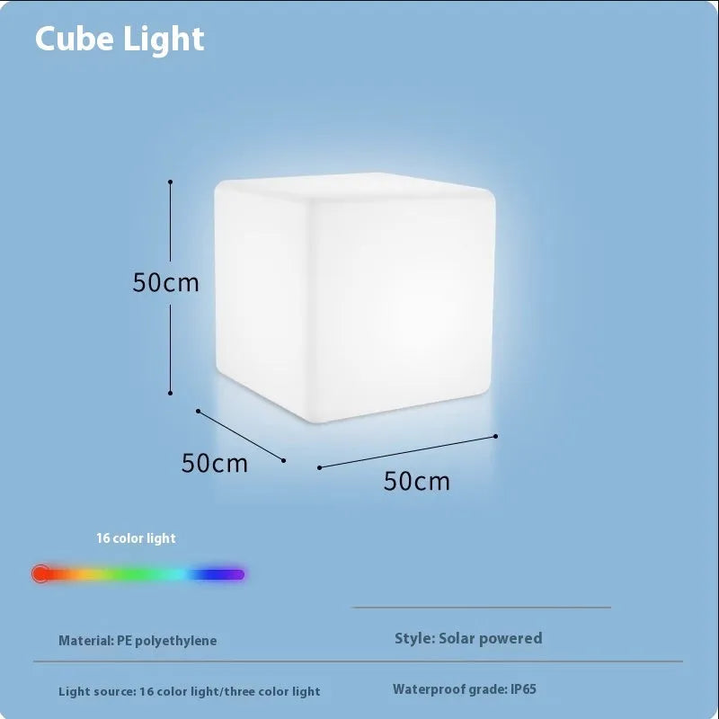 A modern square white LED cube light stool in a garden setting, showing its size options.