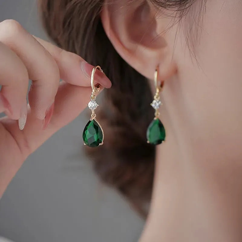 A pair of green geometric teardrop-shaped alloy fashion earrings on a plain background.