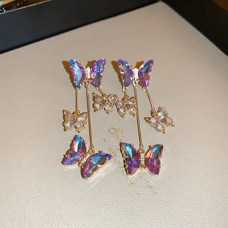 Silver needle and crystal flower earrings with blue purple butterfly tassel on alloy hooks.
