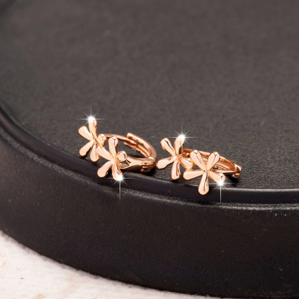 Rose gold circular waterdrop flower earrings with sterling silver posts on a white background.