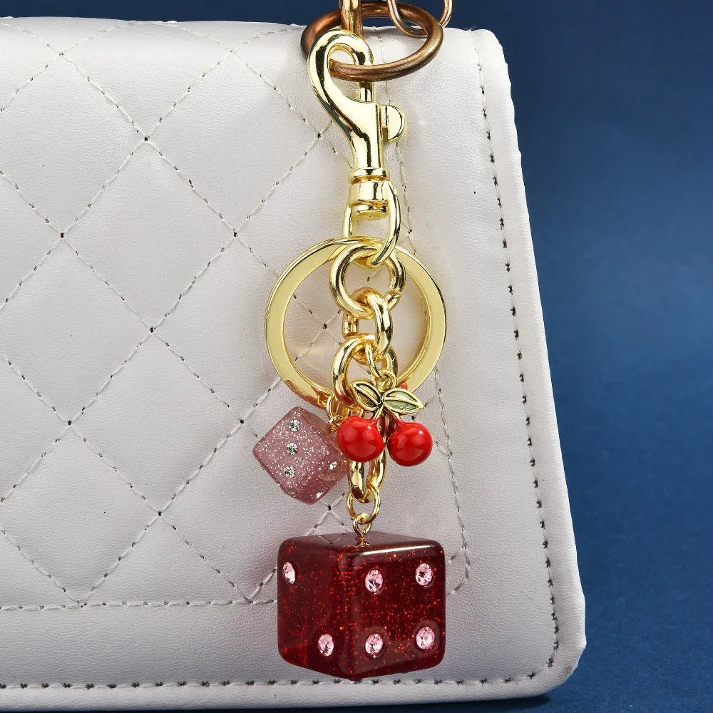 Square cherry red and silver dice pattern metal keychain pendant on a key ring