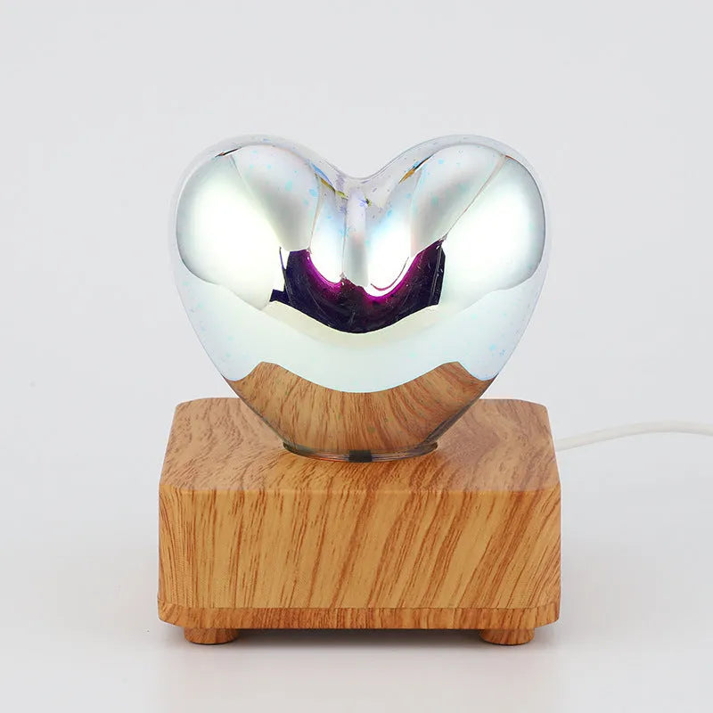 3D love glass small night lamp with silver electroplated finish and solid wood base on a bedside table
