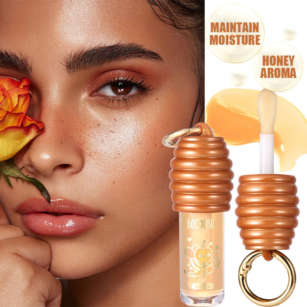 Honey lip gloss attached to a keychain next to a small reusable fabric pannier bag.