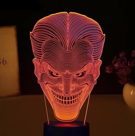 Compact USB-powered 3D LED desk lamp with a touch switch and remote control on a desk.