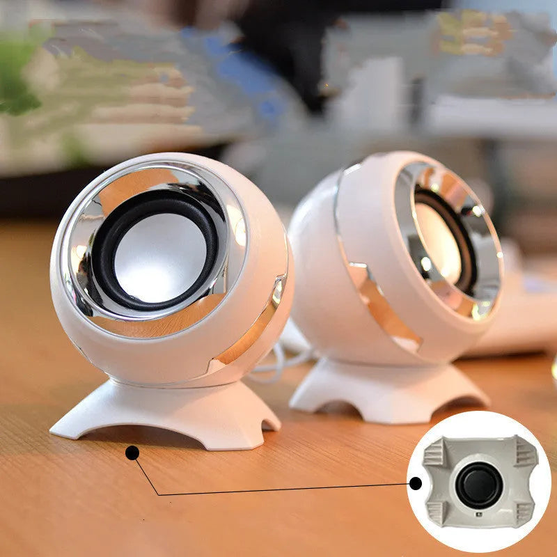 USB-powered computer stereo speakers in black gold and white gold metallic finishes beside laptop