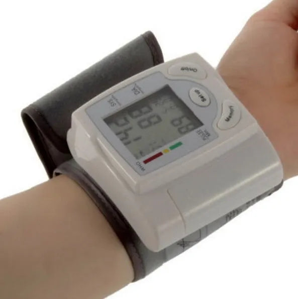 Grey wrist blood pressure monitor with ABS plastic casing showing display and cuff