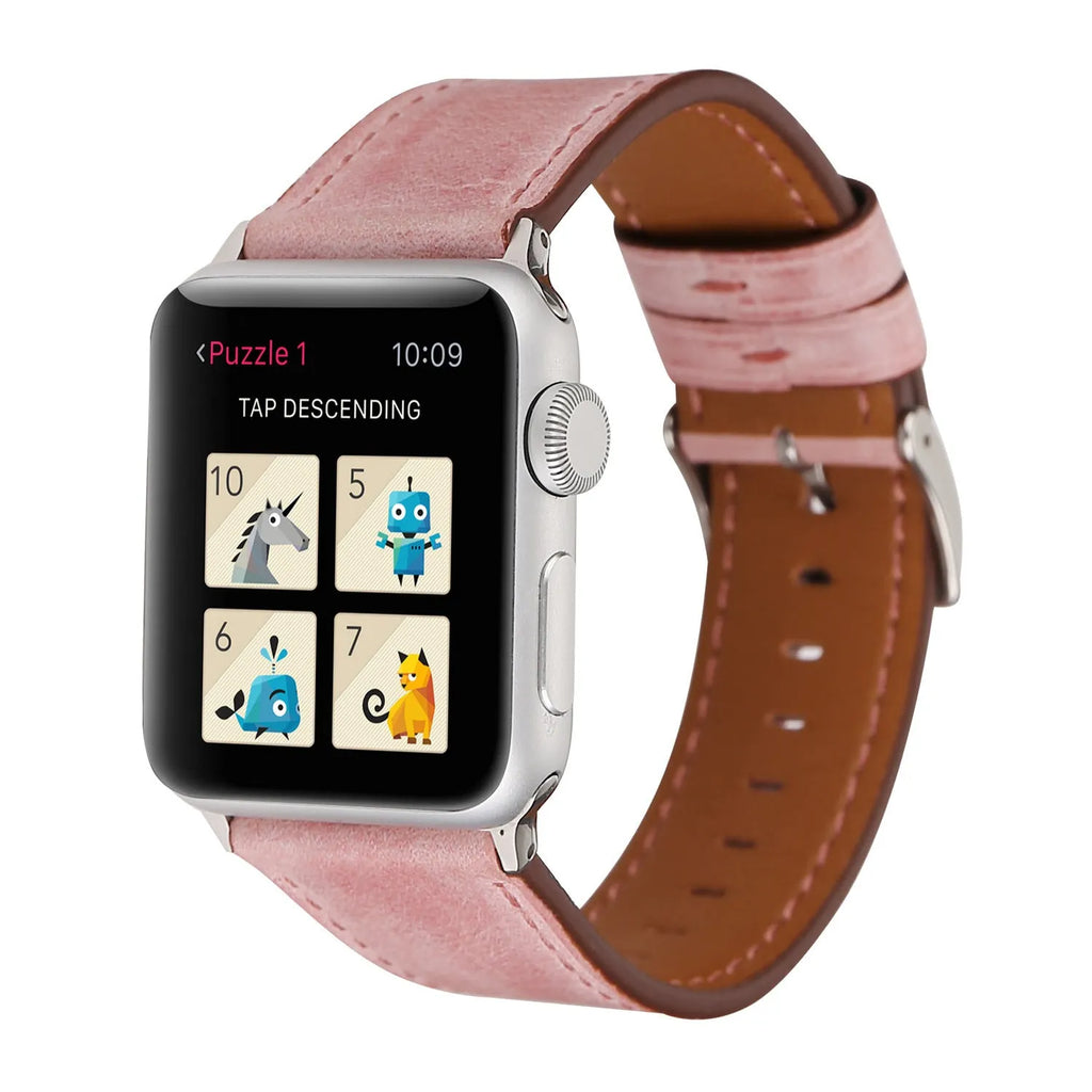 Leather watch strap with a metal folding buckle on a wooden surface.