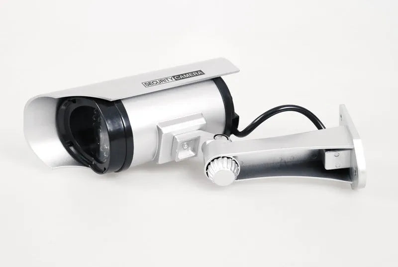 Solar powered fake security camera in black with solar panel on top and red LED light