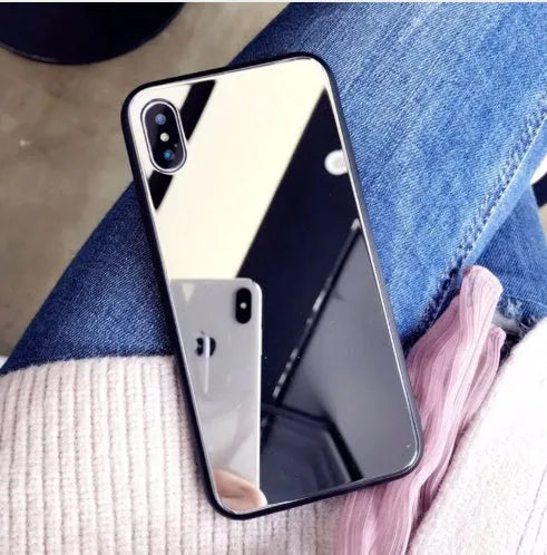 Black iPhone case with a reflective mirror panel on the back, shown fitted to an iPhone.