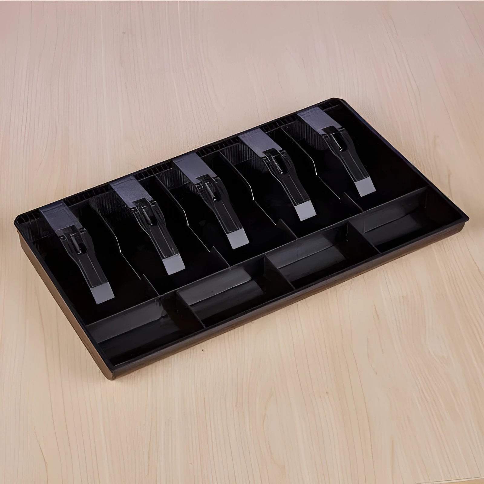 Black and white ABS plastic cash register box with five drawers for banknotes and coins.