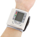 Grey wrist blood pressure monitor with ABS plastic casing showing display and cuff