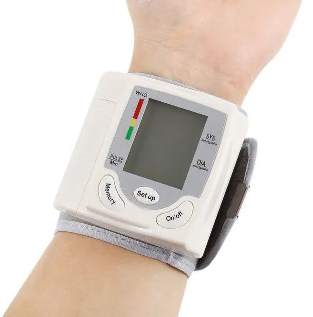Grey wrist blood pressure monitor with ABS plastic casing showing display and cuff