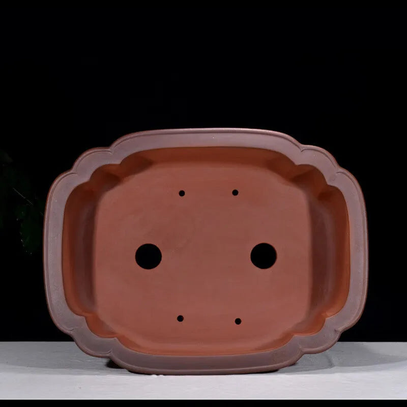 Large antique-style Chinese purple clay flowerpot with tree stump and floral relief pattern.