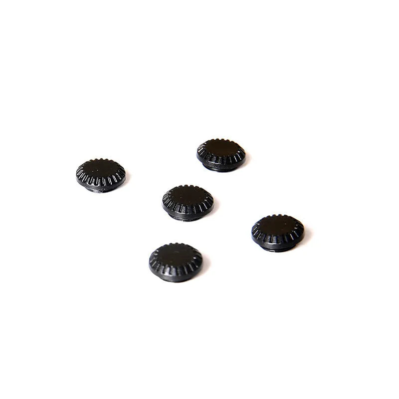 Black plastic camera shutter cover button 1cm diameter on white background