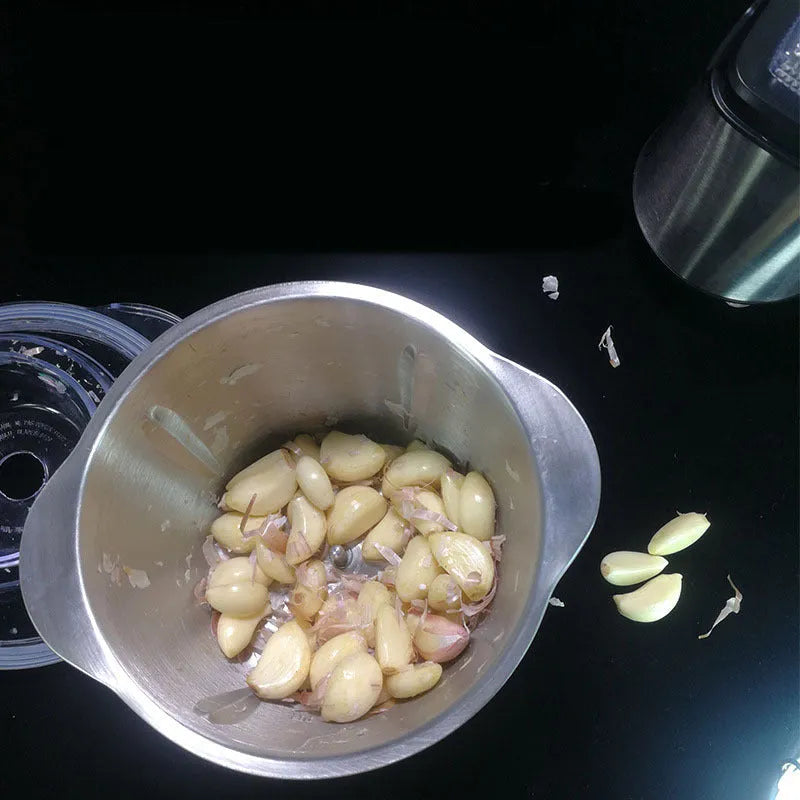 White electric garlic peeler appliance with stainless steel bowl on a kitchen countertop.
