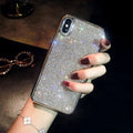 Silver full diamond glitter silicone protective case for iPhone on a table.