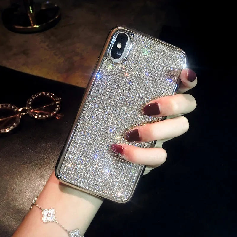 Silver full diamond glitter silicone protective case for iPhone on a table.