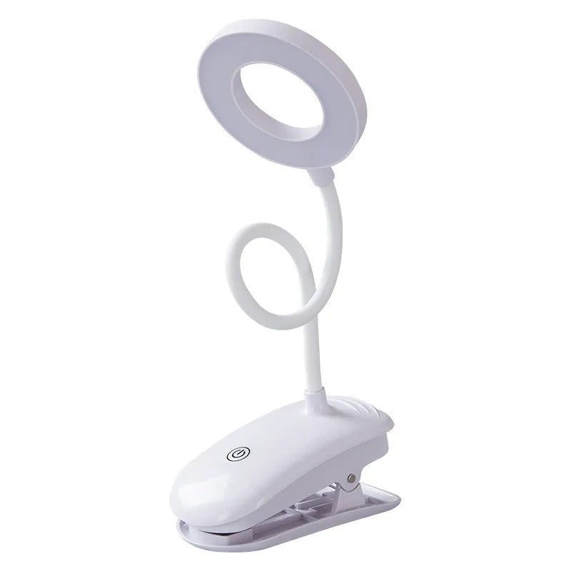 Modern clip-on rechargeable LED desk lamp with touch switch and plastic shade in use on a desk.