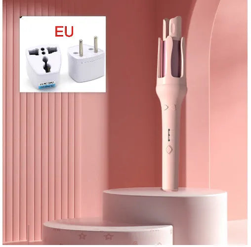 White and pink automatic hair curler with a 32mm rotating ceramic barrel and clamp, resting on a table with international power adapters.