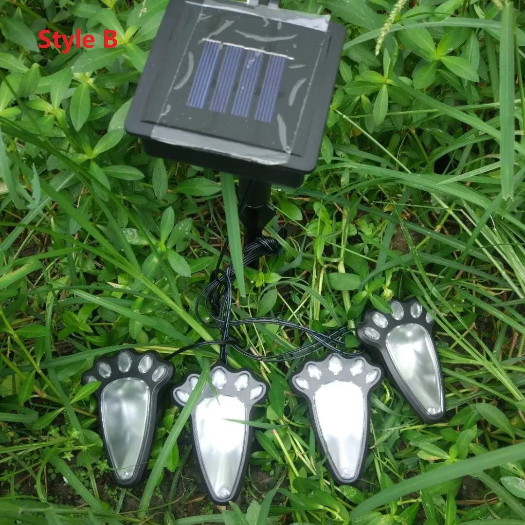 Set of four black bear paw-shaped solar garden lights with solar panel pole