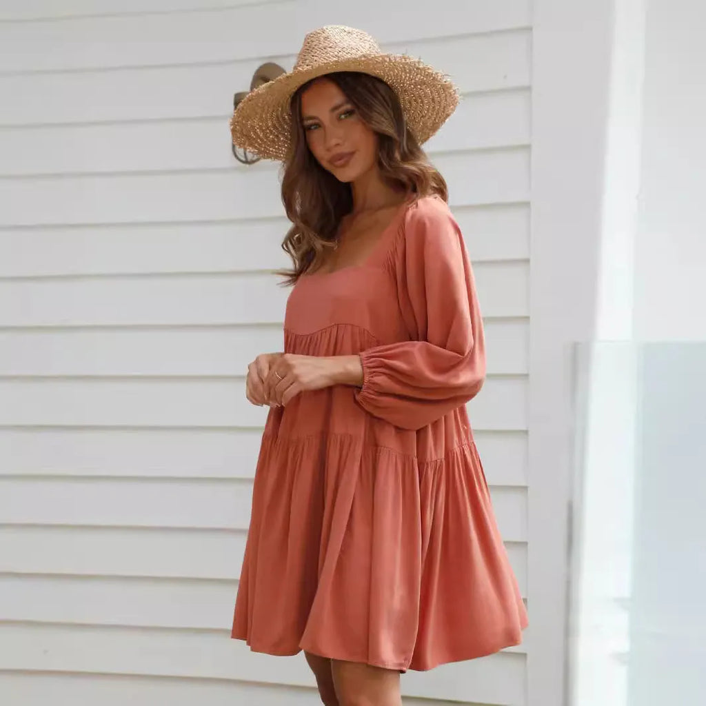 Orange red children's backless pullover dress with puff sleeves and a square collar on a mannequin.