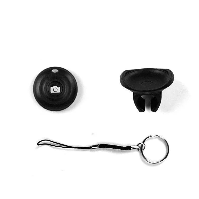 Small black Snap Bluetooth remote shutter next to a smartphone on a tripod, demonstrating wireless camera control.
