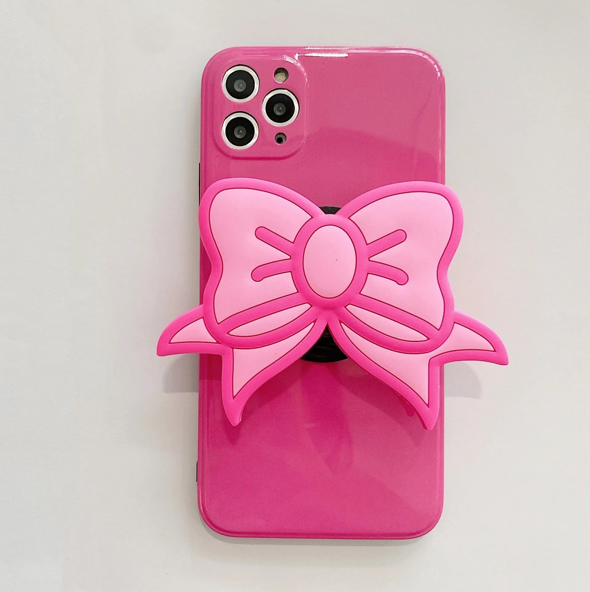 Rose red iPhone case with a pink bow design and a fold-out kickstand on the back.