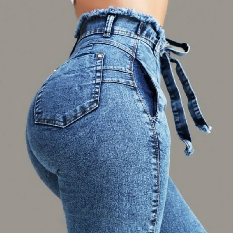 Women's fringed jeans in light blue, grey, and dark blue cowboy fabric, showing detailed fringe hem.