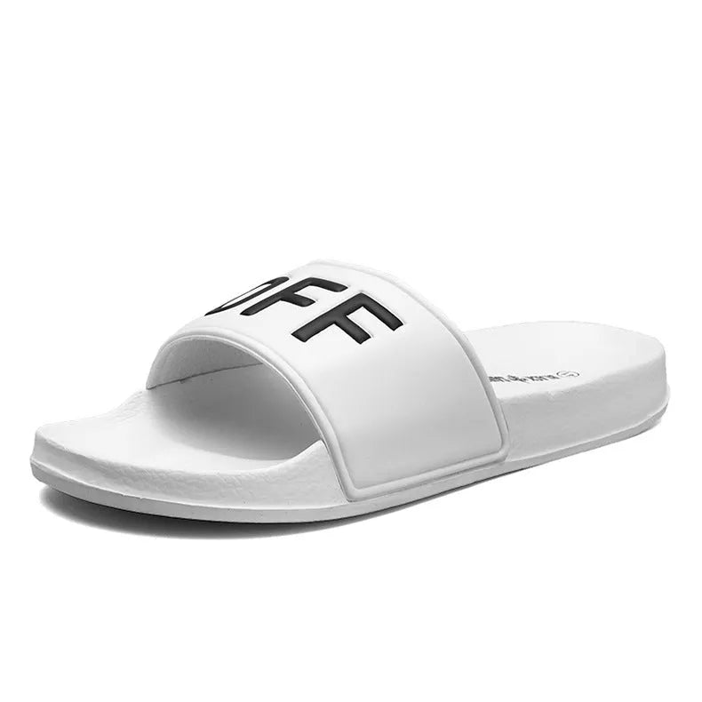 Men's black open-toe slipper with textured rubber sole, shown on a wooden floor.