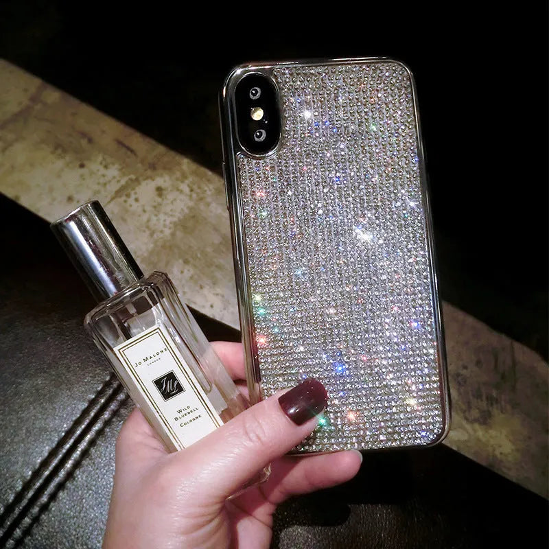 Silver full diamond glitter silicone protective case for iPhone on a table.