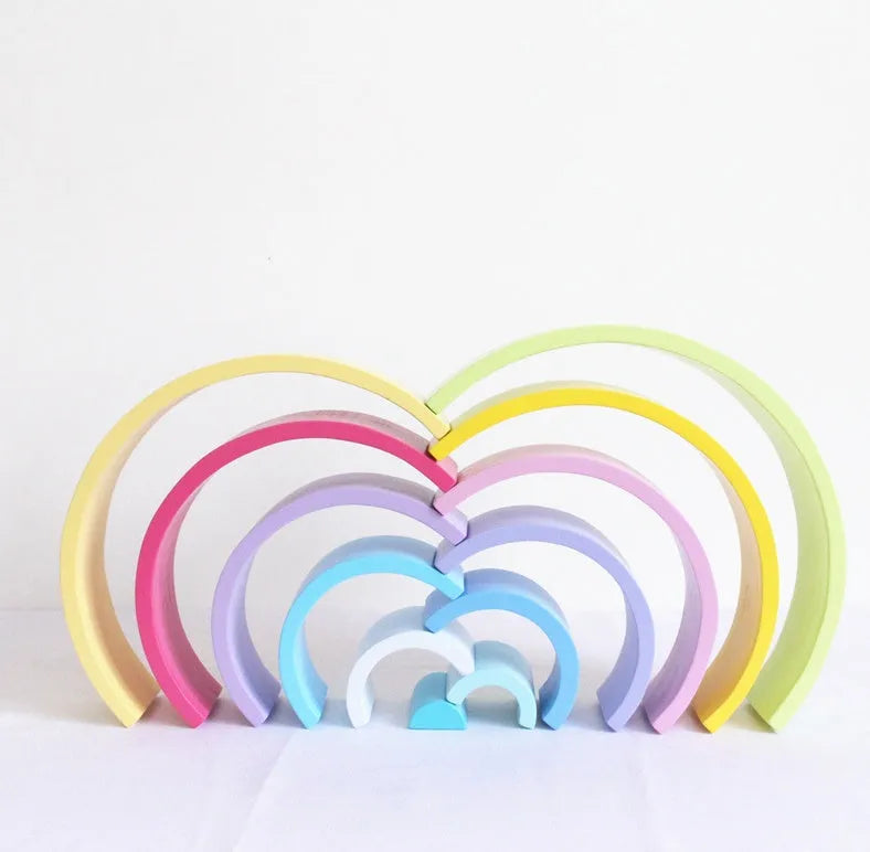 12-piece wooden arch bridge rainbow building blocks made from New Zealand pine with light lacquer finish on a flat surface