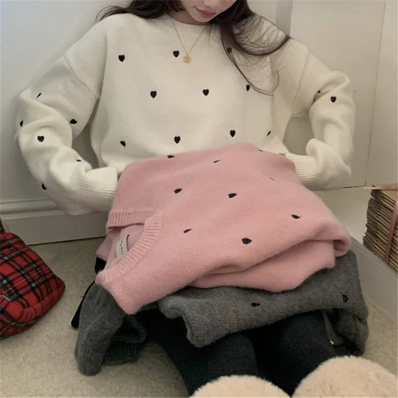 Women's loose grey acrylic pullover sweater with embroidery on the chest and long sleeves.