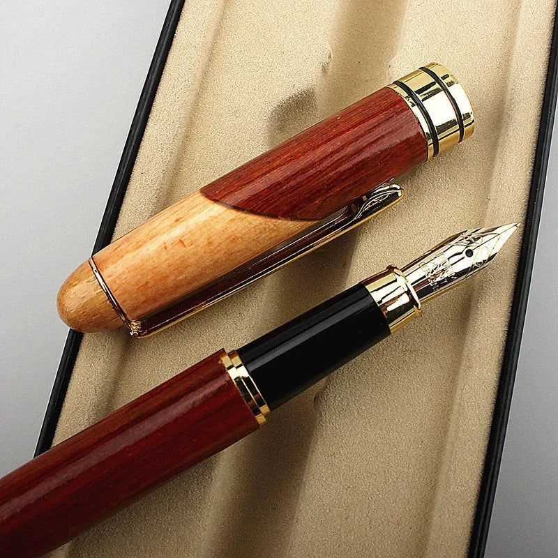 Wooden fountain pen with a metal clip next to a fabric pen bag on a desk.