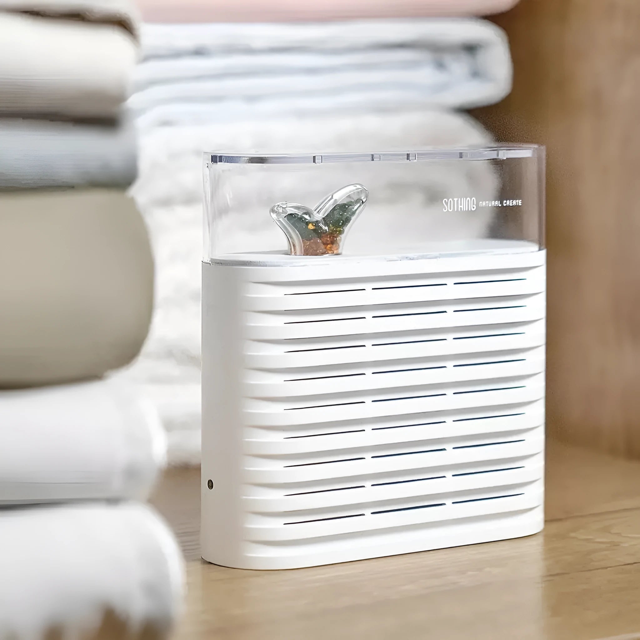 White recyclable cabinet dehumidification box with transparent geometric top cover showing colour-changing silica gel inside.
