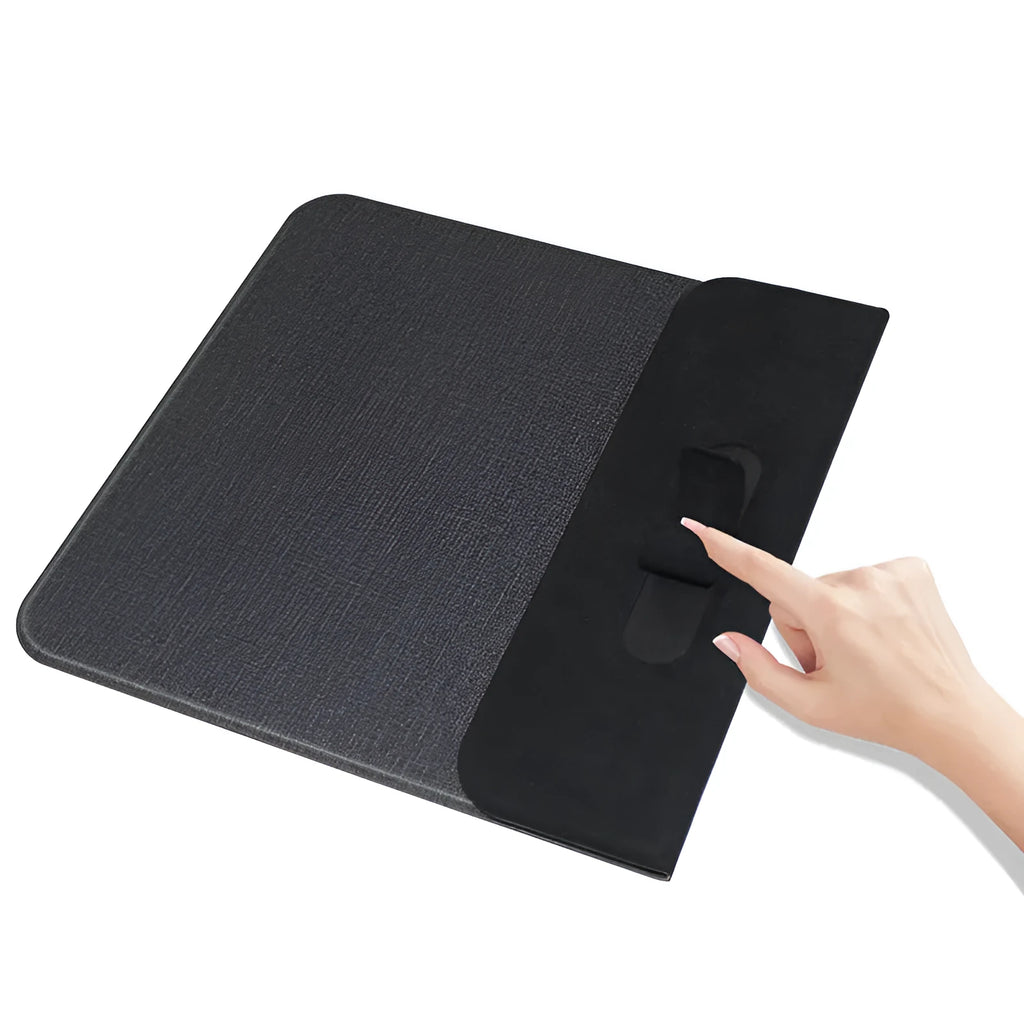 Grey foldable fabric phone holder with smartphone charging wirelessly on a wooden desk