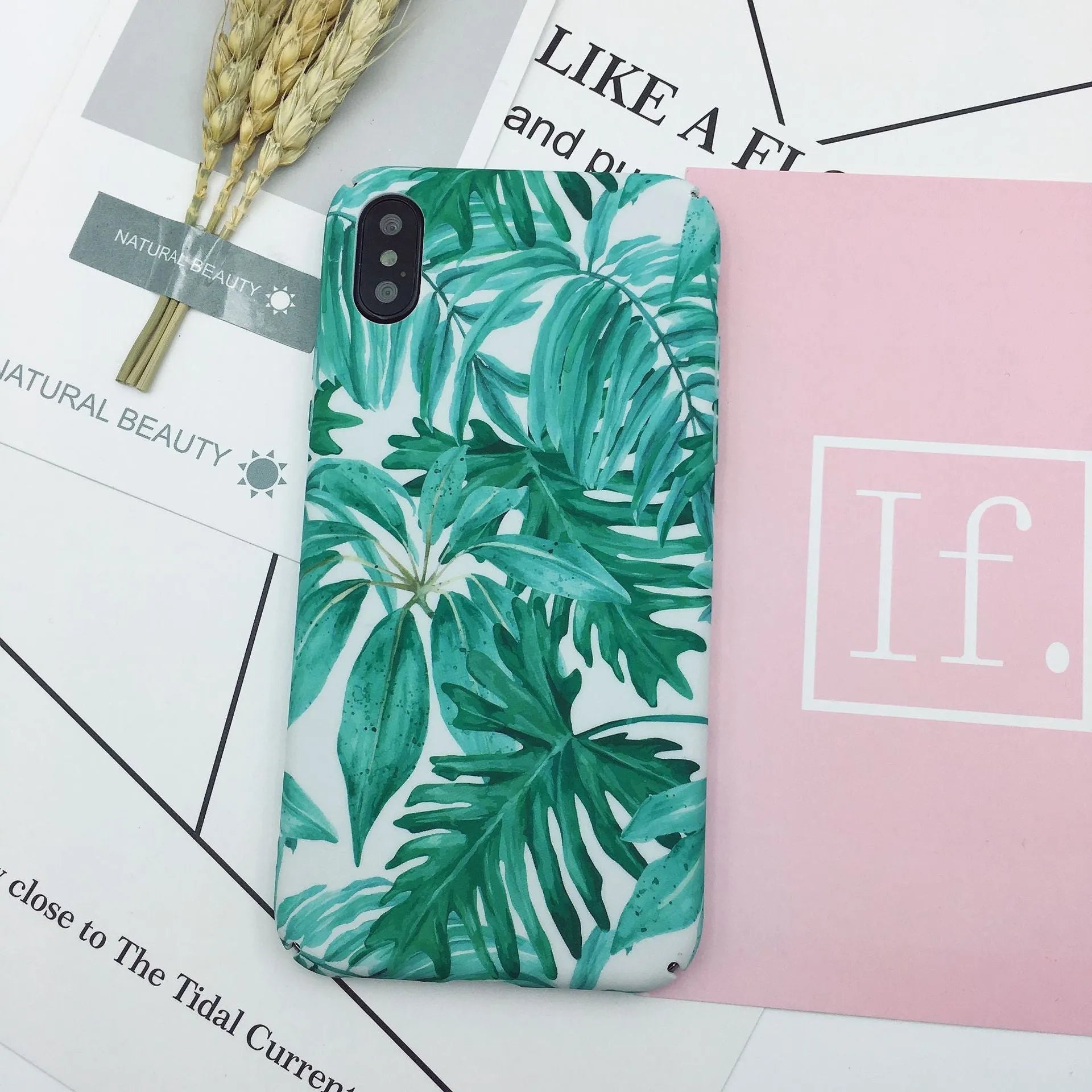 Green and pink painted plastic back cover cases for mobile phones on a white background.