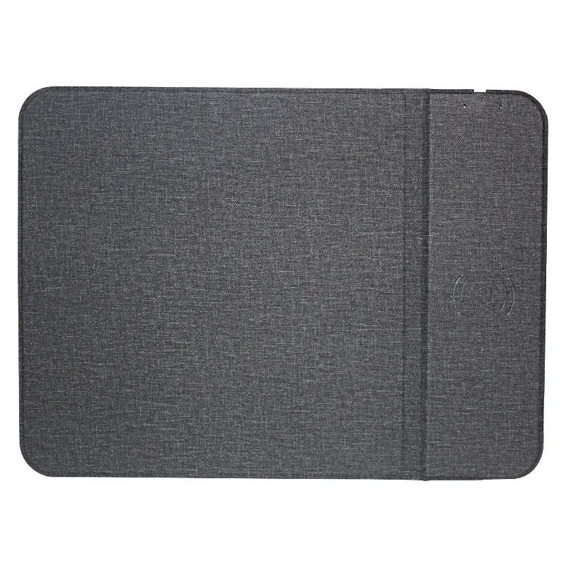 Grey foldable fabric phone holder with smartphone charging wirelessly on a wooden desk