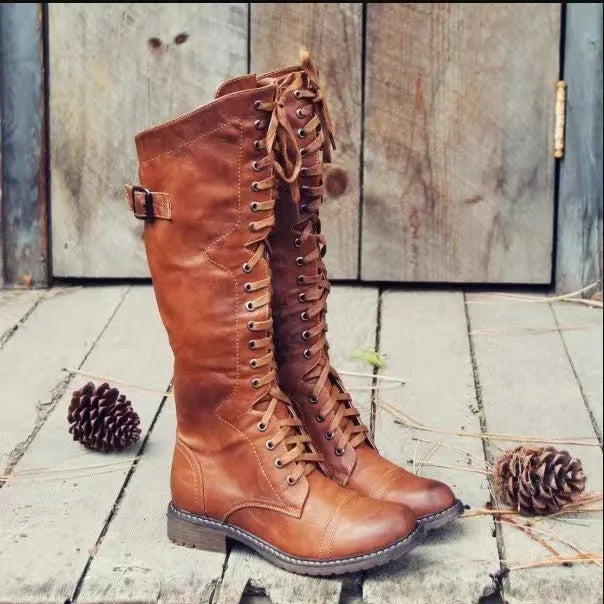 Black women's high-leg boot with a chunky low heel and round toe on a plain background.