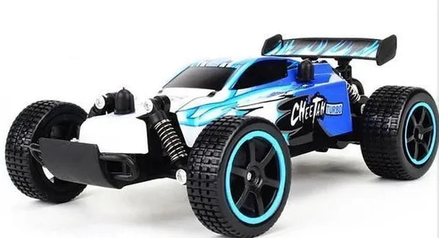 Blue 1:18 scale remote control off-road drift car with 2.4GHz remote on a grey surface.