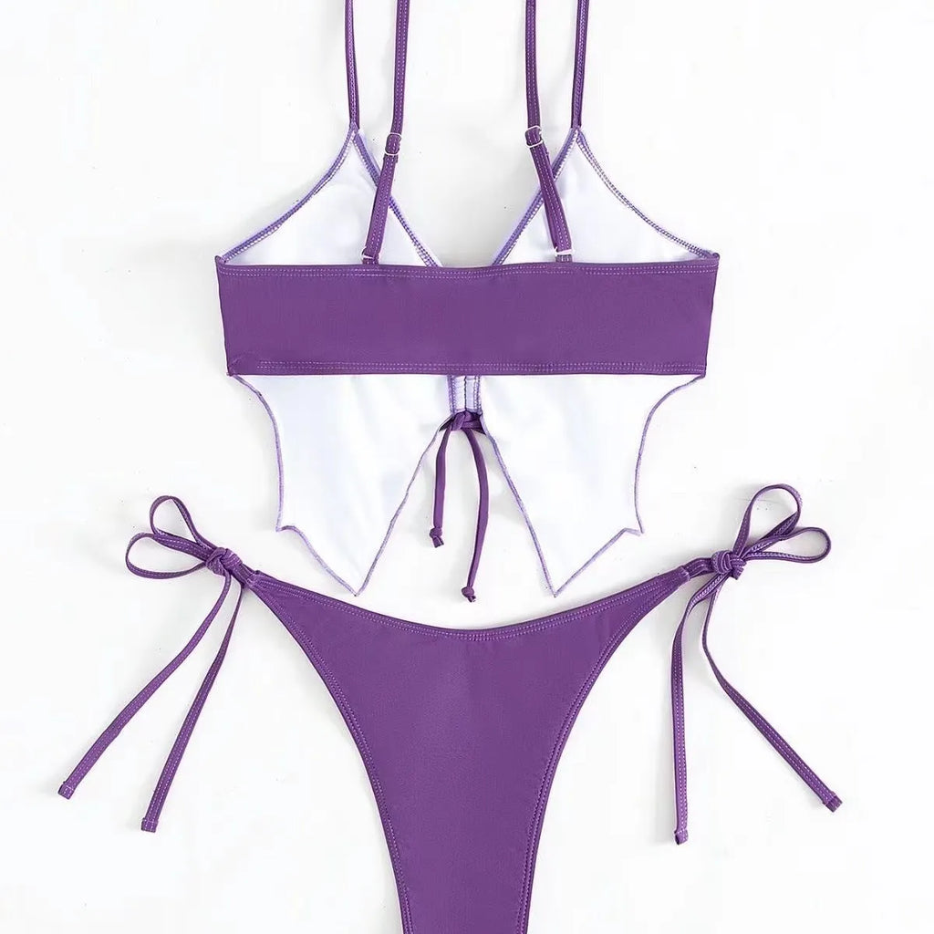 Women's purple split bikini swimsuit with bow detailing on the front, showing sleeveless top and briefs.