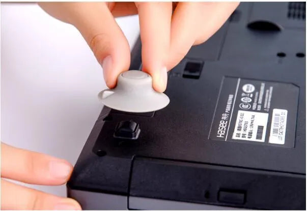Four grey durable plastic laptop cooling pads, two large and two small, on a wooden desk.