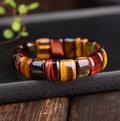 Natural tiger eye stone bracelet with round 14x10mm beads in red colour on a neutral background
