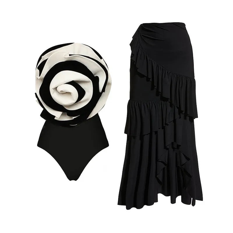 Women's black and white one-piece swimsuit with a detachable matching skirt on a beach.