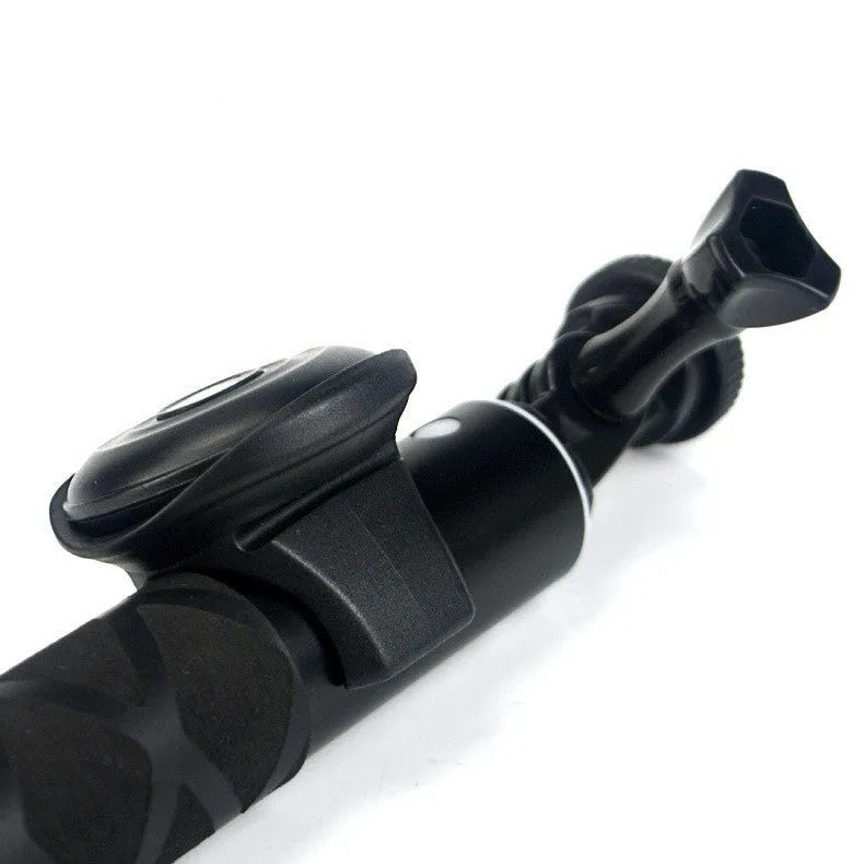 Small black Snap Bluetooth remote shutter next to a smartphone on a tripod, demonstrating wireless camera control.