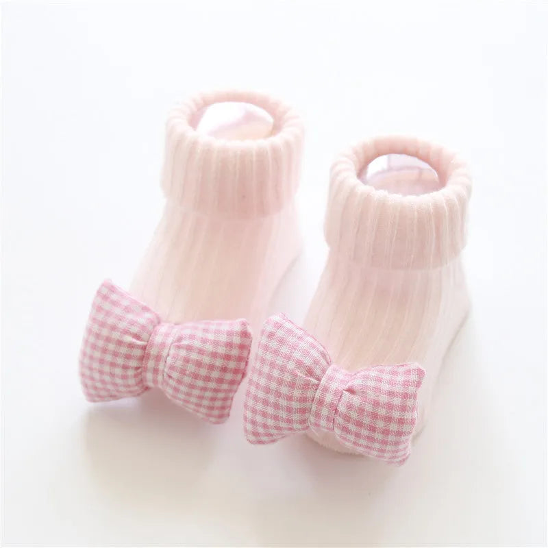 Cotton baby floor socks in assorted colours and prints like blue bow and pink stars on a size chart.