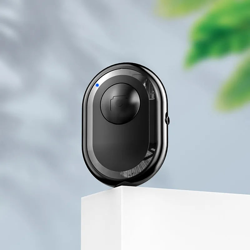 Wireless Bluetooth self-timer remote control in black, pink, and purple colours next to a smartphone.